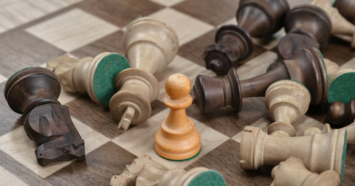 Wooden chess pieces knocked over across a chessboard