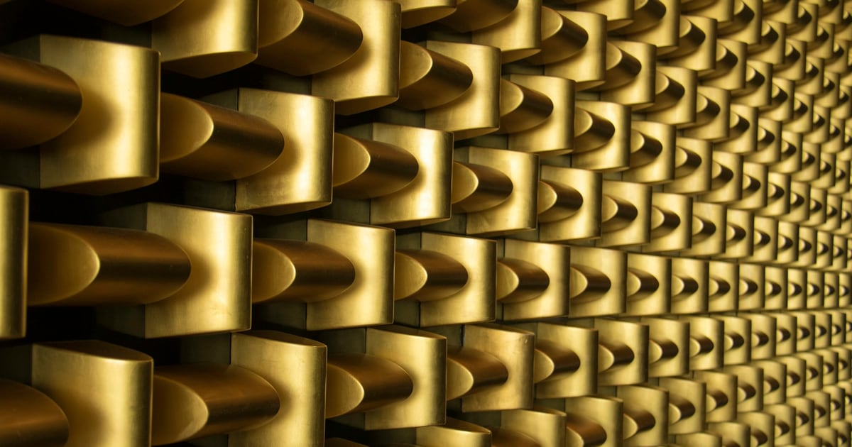 Rows of polished gold-colored blocks forming a repeating wall pattern