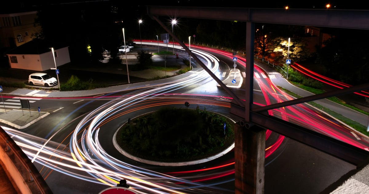 Car light trails circling a roundabout at night